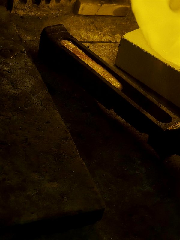 Glühendes Gold wird in die Barrenform gegossen